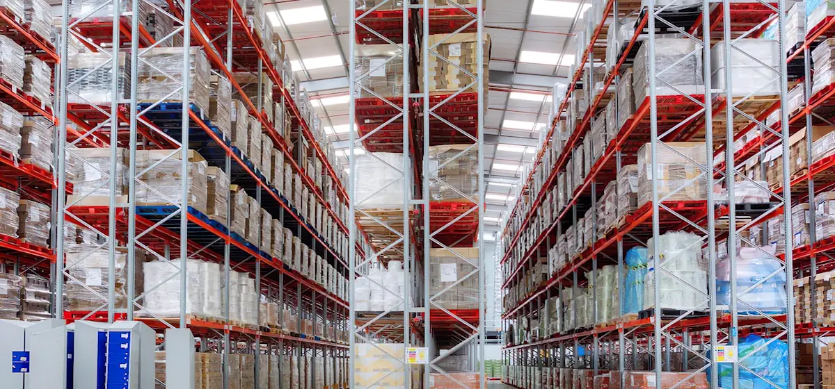 Racks de gran altura con mercancía paletizada dentro de un almacén moderno