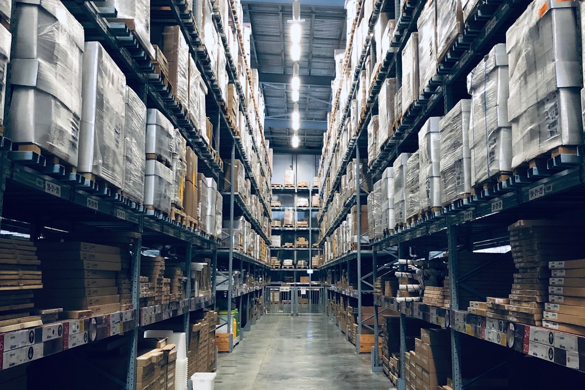 Pasillo de almacén de gran altura con mercancía paletizada sobre racks de acero