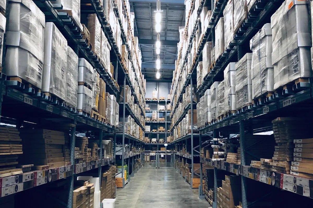 Pasillo de almacén de gran altura con mercancía paletizada sobre racks de acero